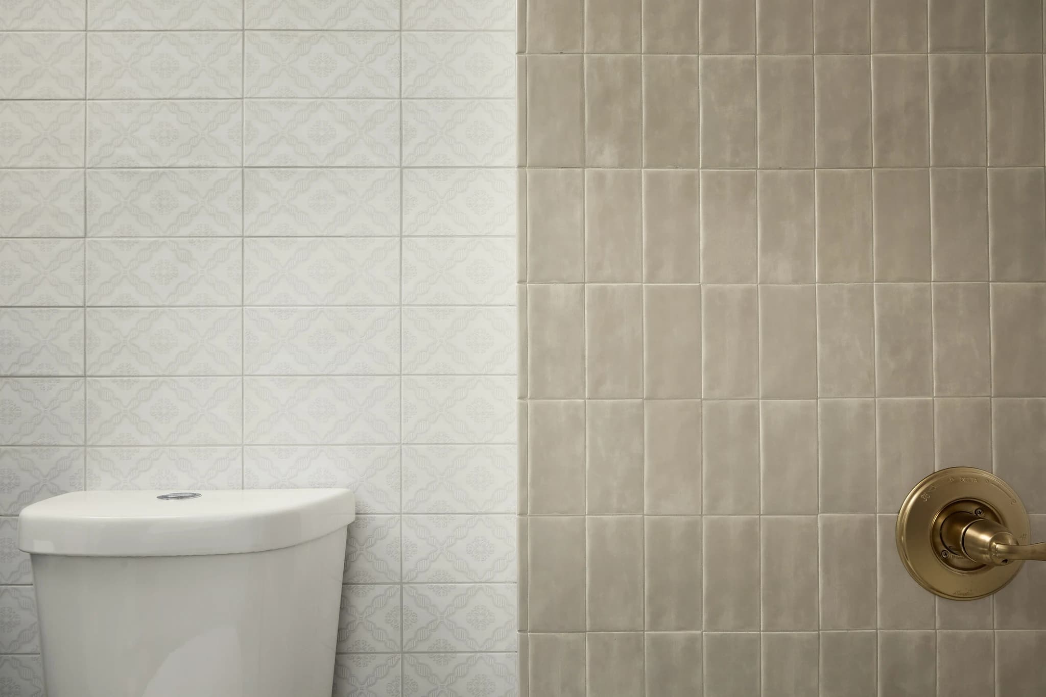 Custom bathroom tilework, brass shower trim, and fixture detail in Meridian-Kessler.