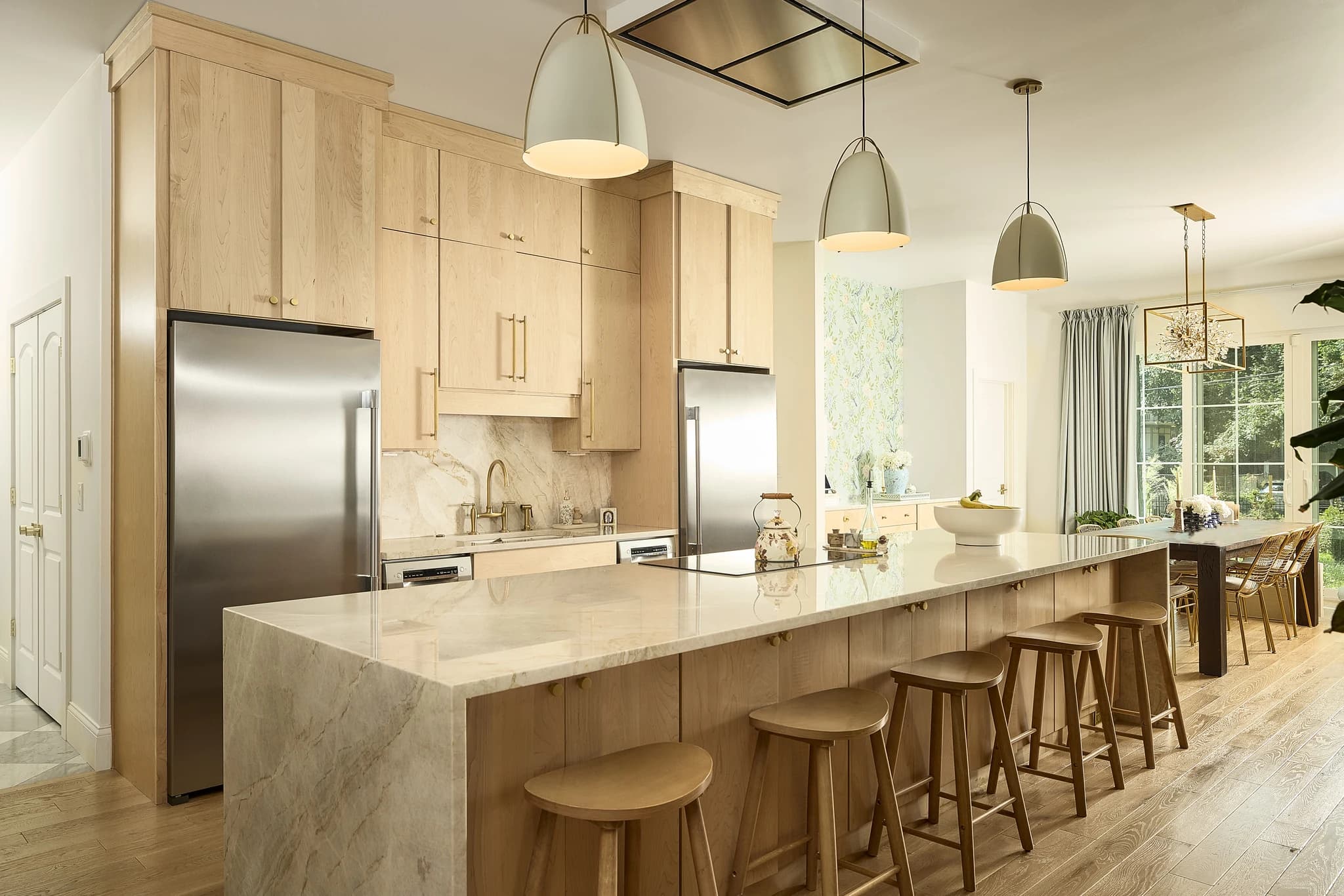 Custom kitchen island with natural wood cabinetry and stone waterfall counters in Meridian-Kessler.