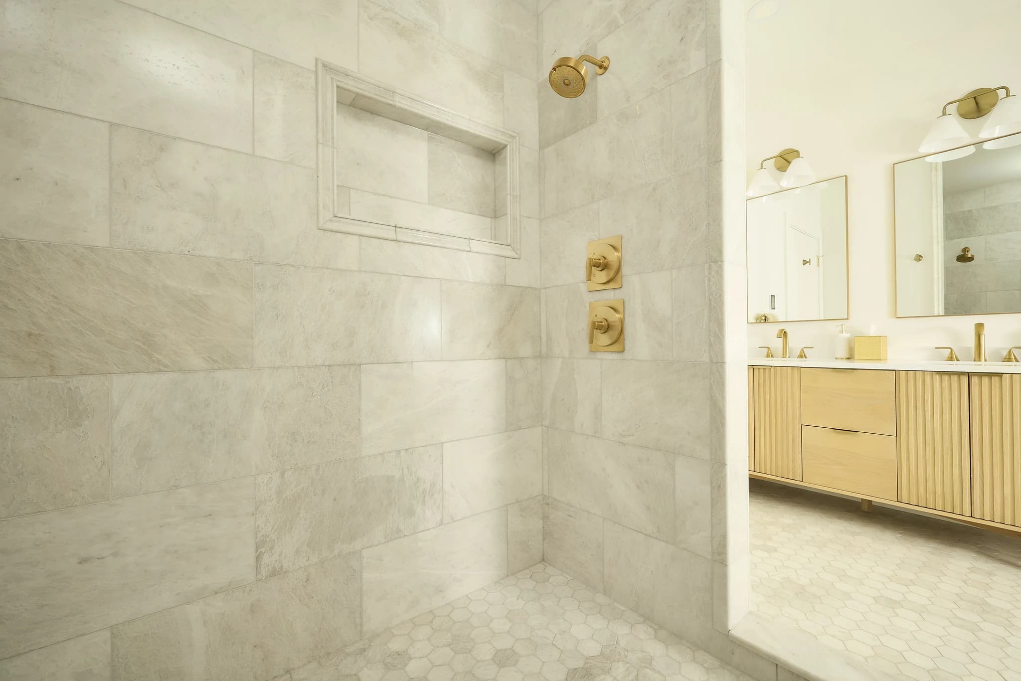 Walk-in tile shower with brass fixtures and a custom detail in a Meridian-Kessler primary bath.